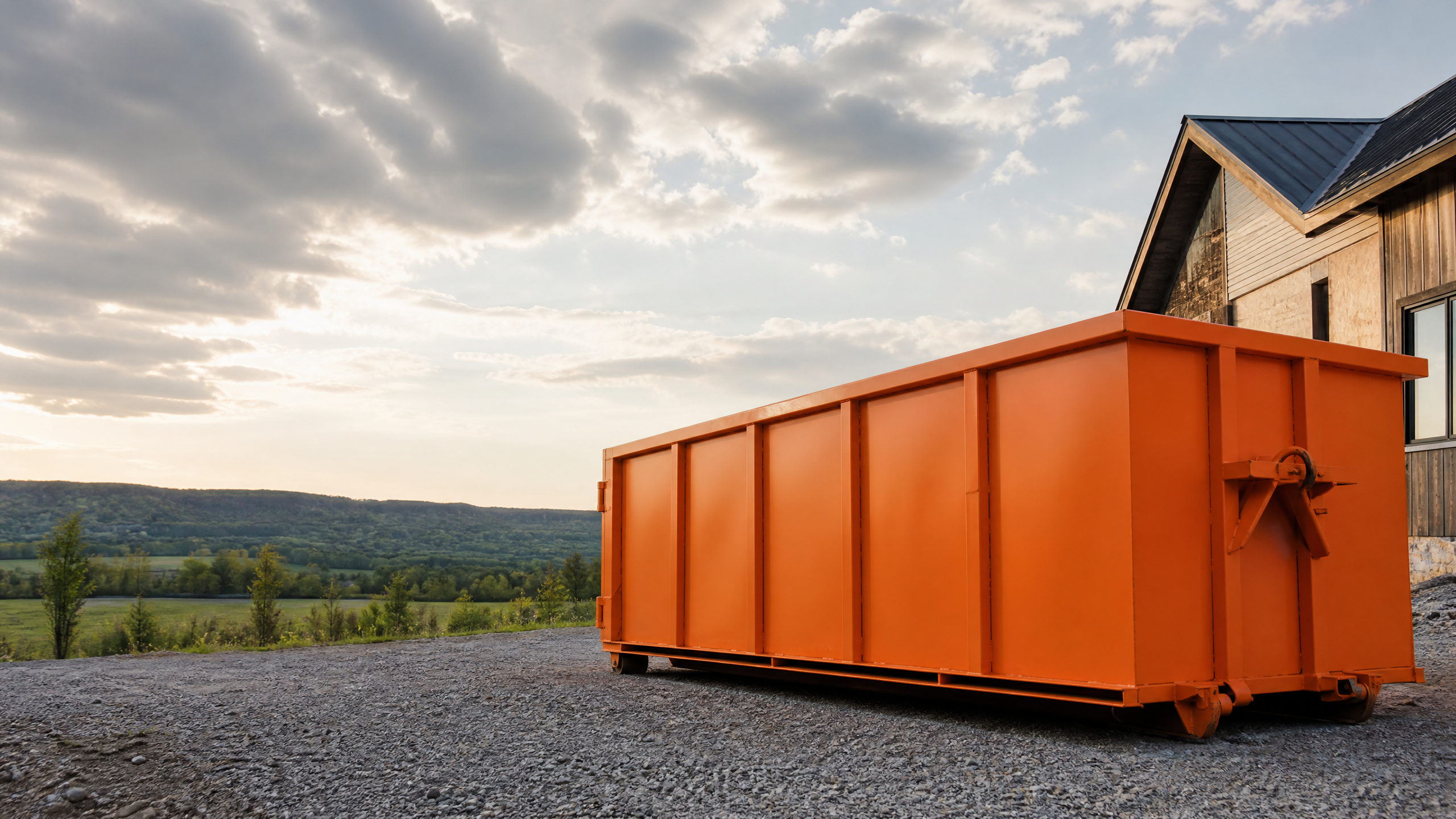 Safety-orange roll-off bin at a rural Ontario project site